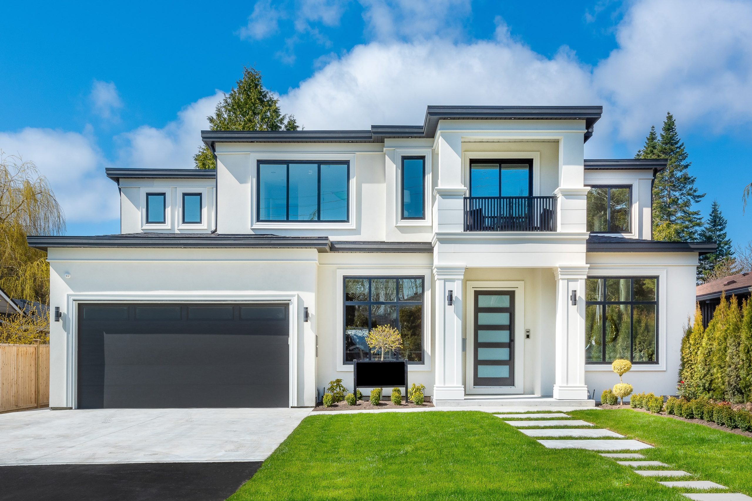 Beautiful contemporary white house with lush grass and blue sky twilight and daylight